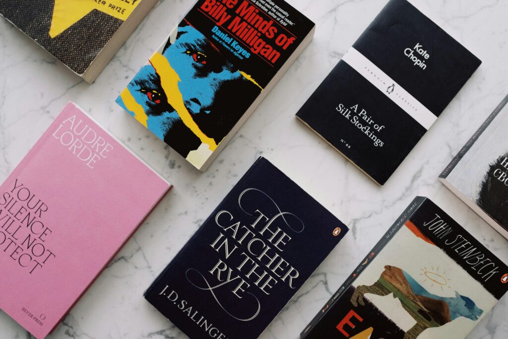 Flat lay of diverse novels on a marble background, showcasing classic literature.